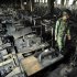 FILE - In this Sunday, Nov. 25, 2012 file photo, a Bangladeshi police officer walks past rows of burnt sewing machines in the burned out Tazreen garment factory in Savar, on the outskirts of Dhaka, Bangladesh. Government investigators said the November fire at the Tazreen factory, which killed 112, was so deadly in part because clothing was stored in the stairwell, which turned the emergency exit into a chimney billowing smoke, fire and toxic fumes from the burning fibers. (AP Photo/Khurshed Rinku, File)