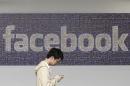 In this June 11, 2014 photo, a man walks past a Facebook sign in an office on the Facebook campus in Menlo Park, Calif. British data protection authorities said Wednesday, July 2, that it is investigating revelations that Facebook conducted a psychological experiment on its users. (AP Photo/Jeff Chiu)