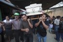 People carry to the cemetery the coffin of one of the four members of the De Leon family, who were killed during a landslide triggered by a 7.4-magnitude earthquake, in El Recreo