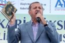 Turkish President Recep Tayyip Erdogan holds a Koran as he speaks during the opening ceremony of the Selehaddin Eyyubi airport in the eastern city of Hakkari, on May 26, 2015