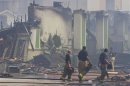 Firefighters gather at the scene of a fire where four firefighters were killed battling a a five-alarm blaze in southwest Houston.