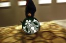 A man carries a Starbucks logo sign after a corporate event at a hotel in Shanghai