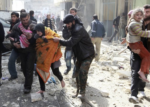 A Free Syrian Army fighter helps a family after a jet missile hit the al-Myassar neighbourhood of Aleppo