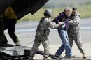 A woman is helped off of a military helicopter at the Boulder Municipal Airport in Boulder, Colo., on on Monday, Sept. 16, 2013, after being rescued. Thousands of people remained stranded by high water and washed out roads in the state. (AP Photo/Ed Andrieski)