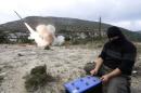 A rebel fighter fires a Grad long distance shell towards forces loyal to Syria's president Bashar Al-Assad located in the city of Jableh at the Syrian coast, from Jabal al-Akrad area in Syria's northwestern Latakia province