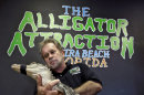 Bob Barrett, owner of The Alligator Attraction poses with one of his alligators Wednesday, Sept. 26, 2012 in Madeira Beach, Fla. Instead of bounce houses and ponies, some Florida parents are opting for more exciting activities at their kid's birthday parties: alligators. Barrett says the parties are totally safe, because the alligators mouths are taped shut. (AP Photo/Chris O'Meara)