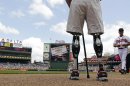 FILE - In this Monday, May 28, 2012 file photo, U.S. Army Capt. Dan Berschinski, foreground, uses prosthetic legs to stand on the field before a baseball game between the St. Louis Cardinals and Atlanta Braves in Atlanta. Berschinski lost both legs to an IED blast while serving in Afghanistan in 2009. Nearly 2,000 American troops have lost a leg, arm, foot or hand in Iraq or Afghanistan, and their sacrifices have led to advances in the immediate and long-term care of survivors, as well in the quality of prosthetics that are now so good that surgeons often chose them over trying to save a badly mangled leg. (AP Photo/David Goldman)