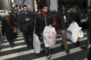 People carry shopping bags as they make their way through the shopping area if Herald Square in New York