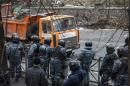 Riot police look on as truck removes barricades at the site of recent clashes with anti-government protesters in Kiev