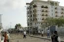 Somali government soldiers stand near the ruins of the Jazeera hotel after an attack in Somalia's capital Mogadishu