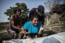 FILE - In this May 28, 2015, file photo, the sister of Alberto Hernández Escalante mourns over the body of her brother, found in a clandestine grave, in a rural area near Caserio el Chumpe, El Salvador. In a report released Monday, Jan. 4, 2016, authorities said that killings spiked by nearly 70 percent in El Salvador in 2015, resulting in a sky-high homicide rate that could make it the world's most violent nation. (AP Photo/Manu Brabo, File)