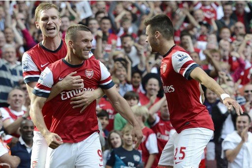 Arsenal's Podolski celebrates with team mate Mertesacker and Jenkinson after scoring against Southampton during their English Premier League soccer match in London