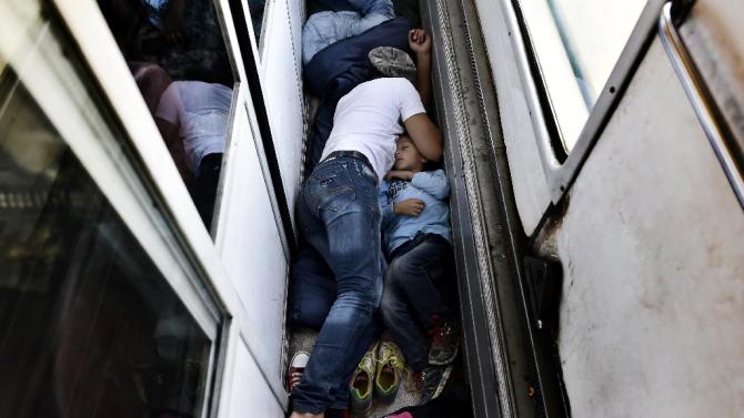 Syrian refugees and migrants sleep on the floor of a carriage as they travel on a train taking them from Macedonia (Also referred to as the Former Yugoslav Republic of Macedonia) to the Serbian border, on August 30, 2015