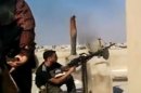 In this image made from amateur video released by the Ugarit News and accessed Tuesday, July 24, 2012, a Free Syrian Army solider fires his weapon during clashes with Syrian government troops in Aleppo, Syria. Turkey sealed its border with Syria to trucks on Wednesday, July 25, 2012 cutting off a vital supply line to the embattled nation as fighting stretched into its fifth day in the commercial capital of Aleppo. (AP Photo/Ugarit News via AP video) TV OUT, THE ASSOCIATED PRESS CANNOT INDEPENDENTLY VERIFY THE CONTENT, DATE, LOCATION OR AUTHENTICITY OF THIS MATERIAL