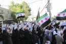 Demonstrators hold Syrian opposition flags during a protest against Syria's President Bashar al-Assad at Kfr Suseh area in Damascus