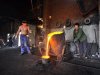Labourers pour molten iron into a container at a foundry in Xiangfan