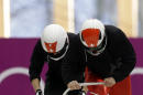 The two-man team from Switzerland SUI-1, piloted by Beat Hefti, start a run during a training session for the men's two-man bobsled at the 2014 Winter Olympics, Friday, Feb. 14, 2014, in Krasnaya Polyana, Russia. (AP Photo/Natacha Pisarenko)