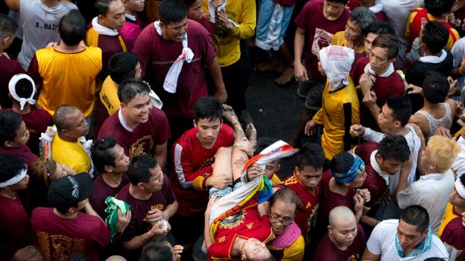 A female devotee is carried away after collapsing during an annual religious procession with the religious icon of the Black Nazarene in Manila on January 9, 2016