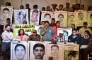 The parents of the missing students from Ayotzinapa hold banners with their portraits as they participate in a press conference in Mexico City on February 9, 2015