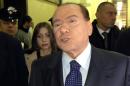 Former Italian Prime Minister Silvio Berlusconi reacts in a corridor of Milan's tribunal during a hearing of the Mediaset trial on March 1, 2013
