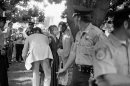 FILE - In this file Sept. 5, 1975 file photo, shows Lynette Fromme, a woman who pointed a gun at President Gerald Ford as he walked from his hotel to the State Capitol in Sacramento, Calif., is taken into custody. Almost 38 years after the assassination attempt, a federal judge has allowed the release of a videotaped testimony given by Ford, that was later used in Fromme's trial. Fromme, a devoted follower of the infamous Charles Manson, wearing a red robe, stepped out from behind a tree and pointed a loaded pistol at the President. (AP Photo/File)