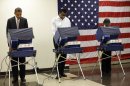 President Barack Obama, left, casts his vote during early voting in the 2012 election Thursday, Oct. 25, 2012, in Chicago, at the Martin Luther King Community Center. (AP Photo/Pablo Martinez Monsivais)