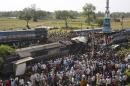 Rescue workers and others gather at the site of a train accident near Bachhrawan village in the northern Indian state of Uttar Pradesh, Friday, March 20, 2015. Police and rescue workers used gas cutters to rip apart the wreckage to find people who were feared to be trapped after three coaches of a passenger train derailed in northern India. (AP Photo/Rajesh Kumar Singh)