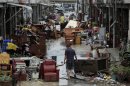 A man walks down a lane of water damaged furniture from heavy rains brought by Typhoon Tembin in Pingtung county, Taiwan, Friday, Aug. 24, 2012. The typhoon crossed over southern Taiwan on Friday morning, causing flooding and wind damage but largely sparing the island's heavily populated areas. (AP Photo) TAIWAN OUT