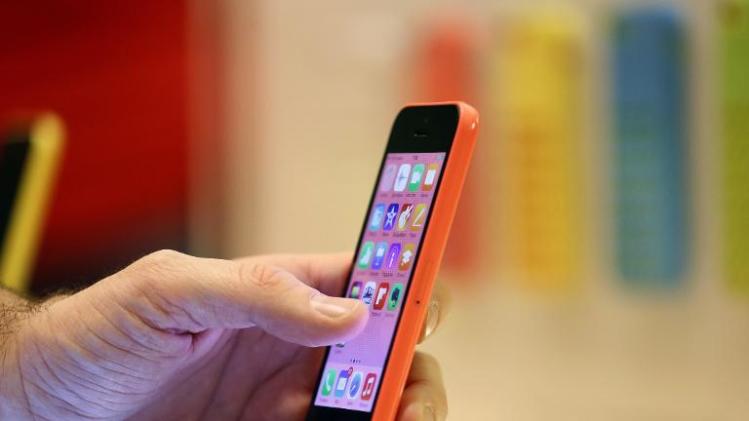 A woman looks at an Apple iPhone at one of the company&#39;s stores in Paris on December 20, 2013