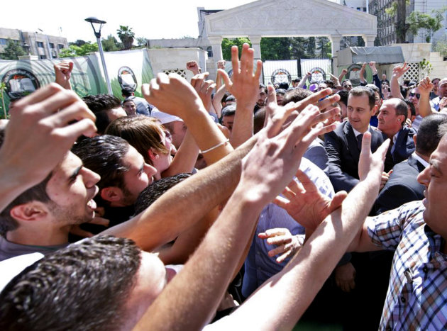 This photo released on the official Facebook page of Syrian President Bashar Assad, shows Syrian president Bashar Assad, right, surrounded by bodyguards as young people, wave at him during the inauguration ceremony on Saturday of a statue dedicated to "martyrs" from Syrian universities who died in the country's two-year-old uprising and civil war, in Damascus, Syria, Saturday, May. 4, 2013. Assad's second public appearance in a week came as Israeli officials confirmed the country's air force carried out a strike against Syria, saying it targeted a shipment of advanced missiles bound for the Lebanese militant group Hezbollah. (AP Photo)