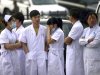 Medical staff wait near a poultry processing plant that was engulfed by a fire in northeast China's Jilin province's Mishazi township on Monday, June 3, 2013. The massive fire broke out at the poultry plant early Monday, trapping workers inside a cluttered slaughterhouse and killing over a hundred people, reports and officials said. (AP Photo) CHINA OUT