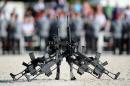 FILE - In this June 5, 2014 file photo G36 rifles of manufacturer Heckler&Koch stand in front of soldiers in Sigmaringen, southern Germany. The widely used assault rifle has "no future" with the German military in its current form, Germany's defense minister Ursula von der Leyen said Wednesday, April 22, 2015, escalating a dispute over the weapon's alleged shortcomings. (Patrick Seeger/dpa via AP, File)