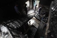 Members of the police inspect a garment factory after a devastating fire in Savar November 25, 2012. REUTERS/Andrew Biraj