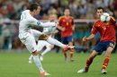 Portugal forward Cristiano Ronaldo (left) strikes towards goal as Spain midfielder Sergio Busquets looks on