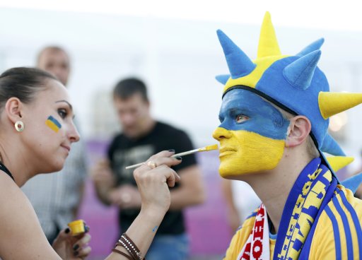 Ukraine fans paint each others faces before their Group D Euro 2012 soccer match against England at the Donbass Arena in Donetsk