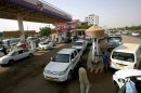 Sudanese queue in a petrol station to fuel their vehicles in Khartoum on June 21, 2012