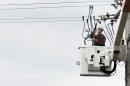 A power company worker in a cherry picker connects wires to a power line while working to restore electricity in East Massapequa
