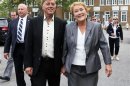 Parti Quebecois leader Marois smiles as she walks with her husband Blanchet following her vote in her home riding in Beaupre, Quebec