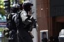 Armed police run toward a cafe in the central business district of Sydney on December 15, 2014