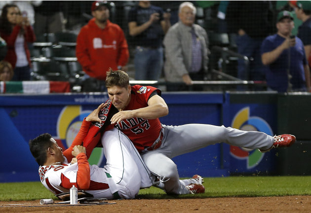 Canada&#39;s Jay Johnson, right, and Mexico&#39;s Eduardo Arredondo fight during the ninth inning of a World Baseball Classic game, Saturday, March 9, 2013, in Phoenix. (AP Photo/Matt York)