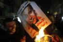 In this Wednesday, Oct. 30, 2013 photo, Supporters of Defense Minister Gen. Abdel-Fattah el-Sissi burn a poster with a photo of Bassem Youssef, the man known as 