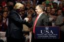U.S. President-elect Donald Trump greets Andrew Nicholas Liveris, Chairman and chief executive officer of The Dow Chemical Company to the stage at a "Thank You USA" tour rally in Grand Rapids