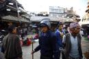 A temporary police personnel patrols around the market in Kathmandu