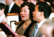 FILE - In this May 25, 1992 file photo, Phan Thi Kim Phuc and her husband, Bui Huy Toan, sing during a service at the Faithway Baptist Church in Ajax, Ontario, Canada. The couple met in Cuba where Kim Phuc was sent from Vietnam to study in 1986. Phuc, who was the main subject in Associated Press photographer Nick Ut's iconic image of the aftermath of a June 8, 1972 napalm attack in Vietnam, was granted political asylum in Canada in 1992. (AP Photo/Nick Ut)
