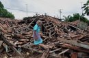 An old woman resident of a rural zone of Acapulco walks amid the rubble of of her home, on September 20, 2013