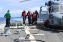 Sailors inspect the flight deck of the Arleigh Burke-class destroyer USS Kidd during search for missing Malaysian airliner