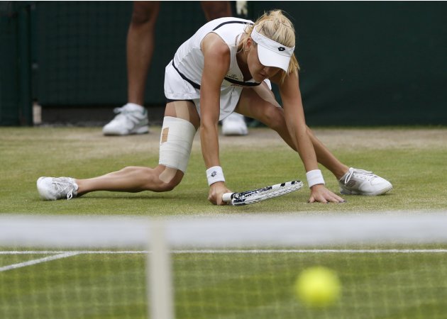 Agnieszka Radwanska of Poland slips in her women's quarter-final tennis match against Li Na of China at the Wimbledon Tennis Championships, in London