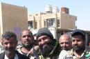 Ayyub Faleh al-Rubaie (centre), known as Abu Azrael -- Father of the Angel of Death -- poses with Shiite fighters at the Speicher military base, near the northern Iraqi city of Tikrit, on March 14, 2015