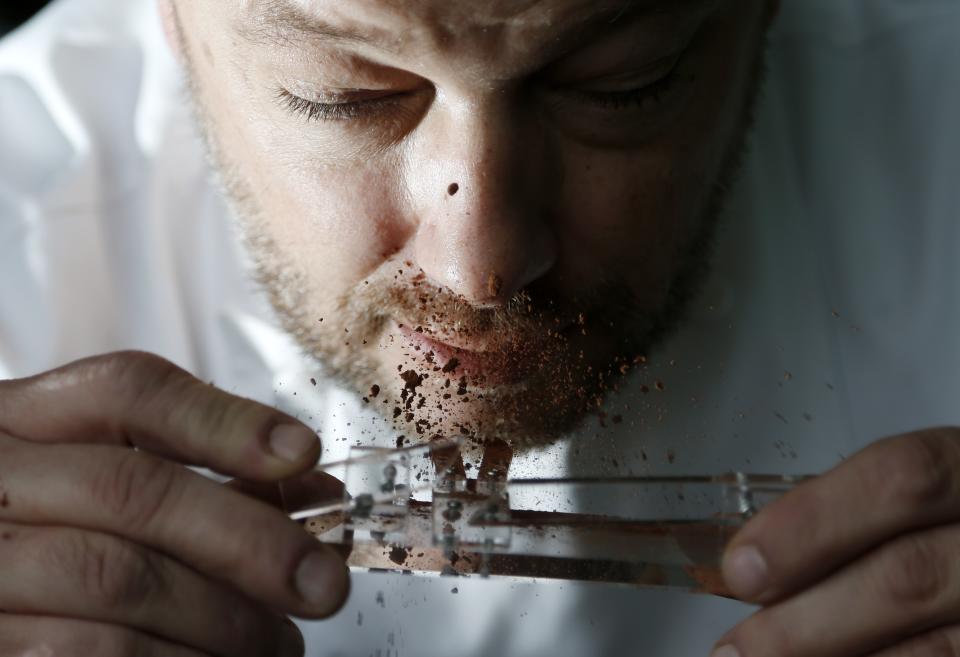Belgian chocolatier Persoone snorts cocoa powder off his Chocolate Shooter in his factory in Bruges