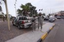 Members of the Libyan security forces stand guard close to the headquarters of the General National Congress in Tripoli